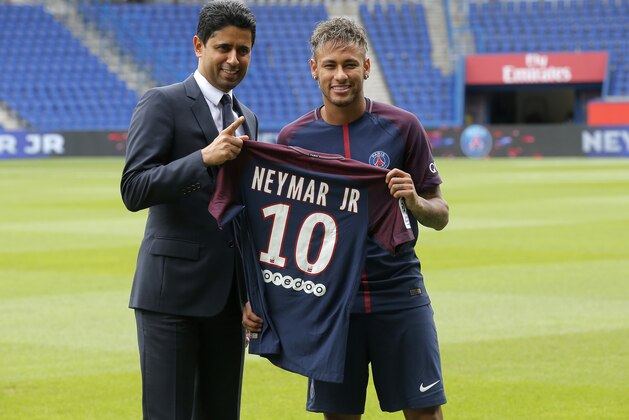 Brazilian soccer star Neymar holds his team shirt as he stands with the chairman of Paris Saint-Germain Nasser Al-Khelaifi following a press conference in Paris Friday, Aug. 4, 2017. Neymar arrived in Paris on Friday the day after he became the most expensive player in soccer history when completing his blockbuster transfer to Paris Saint-Germain from Barcelona for 222 million euros ($262 million).(AP Photo/Michel Euler)