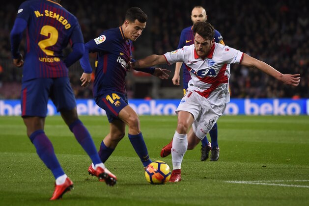 Barcelona's Brazilian midfielder Philippe Coutinho (2L) vies with Alaves' Spanish forward Ibai Gomez during the Spanish league football match between FC Barcelona and Deportivo Alaves at the Camp Nou stadium in Barcelona on January 28, 2018. / AFP PHOTO / Josep LAGO        (Photo credit should read JOSEP LAGO/AFP/Getty Images)