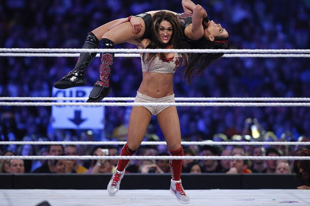 FILE - In this April 6, 2014, file photo, Brie Bella and Nikki Bella, known as the Bella Twins, compete during Wrestlemania XXX at the Mercedes-Benz Super Dome in New Orleans. (Jonathan Bachman/AP Images for WWE)