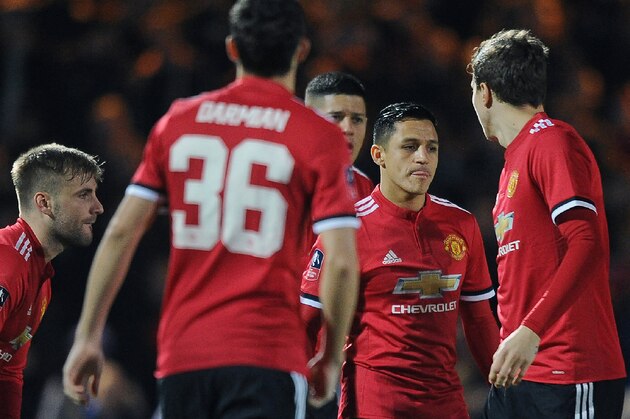 Manchester United's Chilean striker Alexis Sanchez (2R) walks onto the pitch with his teammates ahead of the FA Cup fourth round football match between Yeovil Town and Manchester United at Huish Park in Yeovil, Somerset on January 26, 2018. / AFP PHOTO / - / RESTRICTED TO EDITORIAL USE. No use with unauthorized audio, video, data, fixture lists, club/league logos or 'live' services. Online in-match use limited to 75 images, no video emulation. No use in betting, games or single club/league/player publications.  /         (Photo credit should read -/AFP/Getty Images)