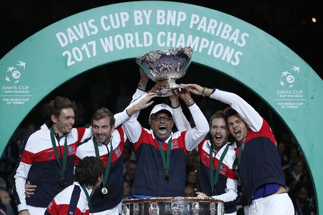 French captain Yannick Noah, center, holds the cup after France won the Davis Cup at the Pierre Mauroy stadium in Lille, northern France, Sunday, Nov.26, 2017. France won the Davis Cup for the first time in 16 years after beating Belgium 3-2. (AP Photo/Christophe Ena)
