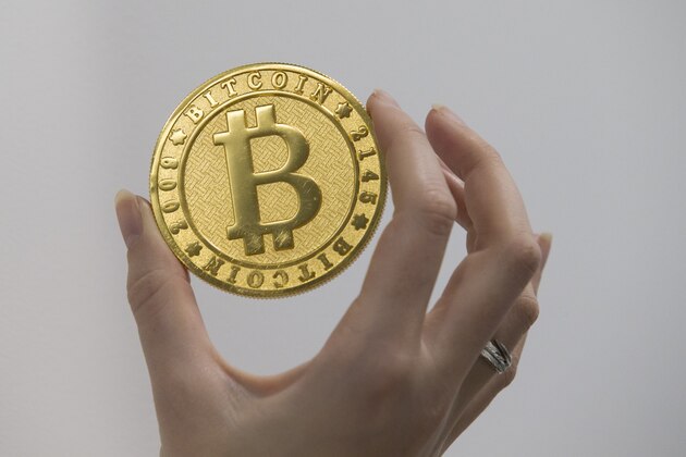 A person holds on January 17, 2018 a visual representation of the digital cryptocurrency Bitcoin, at La Maison du Bitcoin in Paris. / AFP PHOTO / GEOFFROY VAN DER HASSELT        (Photo credit should read GEOFFROY VAN DER HASSELT/AFP/Getty Images)