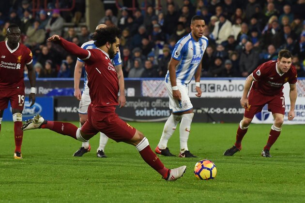 Liverpool's Egyptian midfielder Mohamed Salah scores their third goal from the penalty spot during the English Premier League football match between Huddersfield Town and Liverpool at the John Smith's stadium in Huddersfield, northern England on January 30, 2018. / AFP PHOTO / PAUL ELLIS / RESTRICTED TO EDITORIAL USE. No use with unauthorized audio, video, data, fixture lists, club/league logos or 'live' services. Online in-match use limited to 75 images, no video emulation. No use in betting, games or single club/league/player publications.  /         (Photo credit should read PAUL ELLIS/AFP/Getty Images)