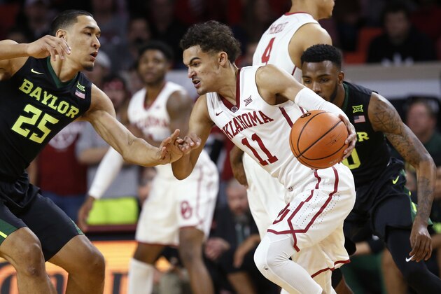 Oklahoma guard Trae Young (11) drives between Baylor forward Tristan Clark (25) and guard Tyson Jolly, right, during the first half of an NCAA college basketball game in Norman, Okla., Tuesday, Jan. 30, 2018. (AP Photo/Sue Ogrocki)