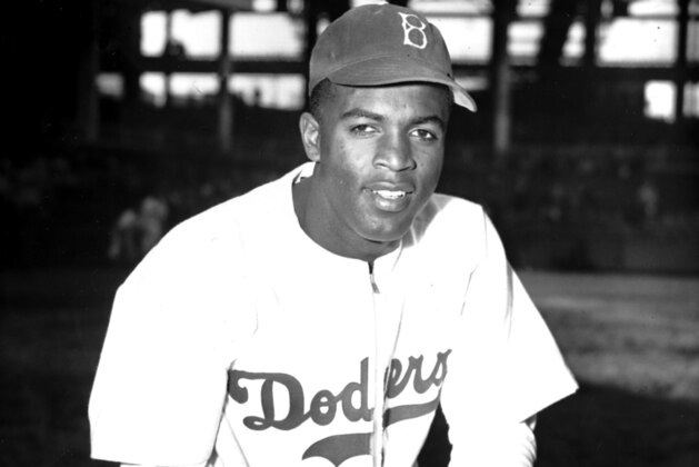 FILE - In this April 11, 1947 file photo, Jackie Robinson of the Brooklyn Dodgers poses at Ebbets Field in the Brooklyn borough of New York. A specially padded baseball cap that Jackie Robinson wore for protection against beanballs has sold for $590,994 at auction.The blue Brooklyn Dodgers hat sold Saturday, Oct. 28, 2017, after a monthlong online auction through the sports auctioneers Lelands. Lelands says Robinson wore the hat when he broke baseball’s color barrier in 1947. (AP Photo/John Rooney, File)
