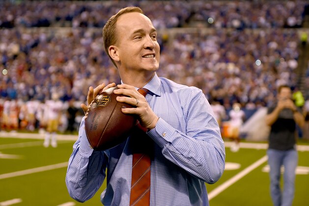INDIANAPOLIS, IN - OCTOBER 08: Peyton Manning steps back to throw a pass to former teammate Marvin Harrison during a presentation to retire Manning's number during the halftime of the game between the Indianapolis Colts and the San Francisco 49ers at Lucas Oil Stadium on October 8, 2017 in Indianapolis, Indiana.  (Photo by Bobby Ellis/Getty Images)