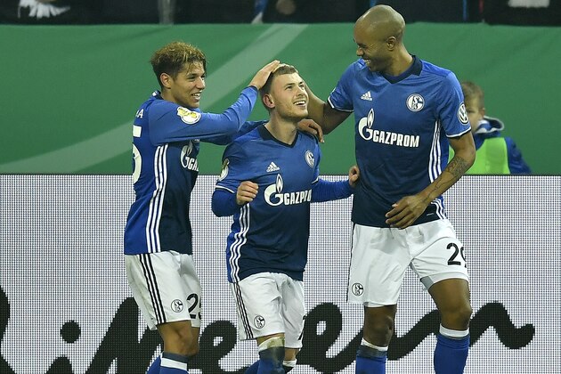 Schalke's Max Meyer, center, is celebrated by Amine Harit, left, and Naldo, right, after scoring the opening goal during the German soccer cup match between FC Schalke 04 and 1. FC Cologne in Gelsenkirchen, Germany, Tuesday, Dec. 19, 2017. (AP Photo/Martin Meissner)