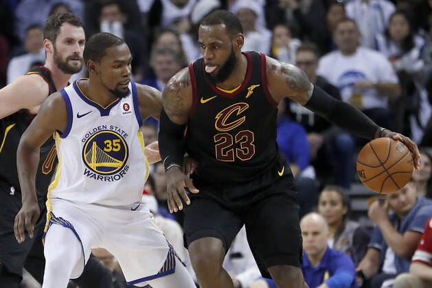 Cleveland Cavaliers forward LeBron James (23) moves the ball around Golden State Warriors forward Kevin Durant (35) during the second half of an NBA basketball game in Oakland, Calif., Monday, Dec. 25, 2017. The Warriors won 99-92. (AP Photo/Tony Avelar)