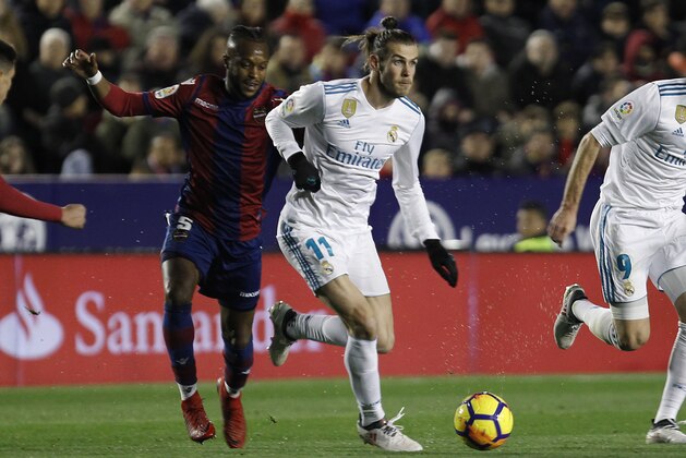 Real Madrid's Gareth Bale, right, duels for the ball with Levante's DouKoure,left, during the Spanish La Liga soccer match between Levante and Real Madrid at the Ciutat de Valencia stadium in Valencia, Spain, Saturday, Feb. 3, 2018. (AP Photo/Alberto Saiz)