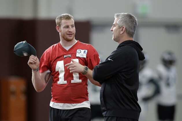 Injures Philadelphia Eagles quarterback Carson Wentz (11) talks with offensive coordinator Frank Reich, right, during a practice for the NFL Super Bowl 52 football game Thursday, Feb. 1, 2018, in Minneapolis. Philadelphia is scheduled to face the New England Patriots Sunday. (AP Photo/Eric Gay)