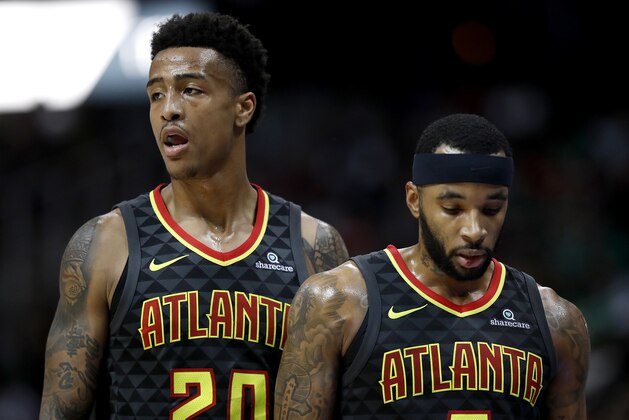 Atlanta Hawks' John Collins, left, and teammate Malcolm Delaney walk to the bench during a timeout in the fourth quarter of an NBA basketball game against the Boston Celtics in Atlanta, Saturday, Nov. 18, 2017. Boston won 110-99. (AP Photo/David Goldman)