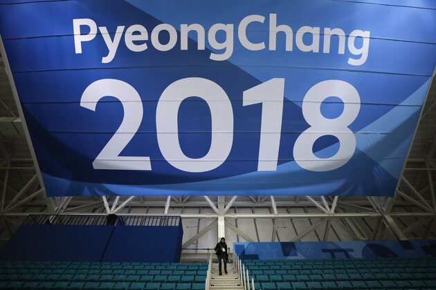 FILE - In this Feb. 6, 2018 file photo, a photographer walks down the steps underneath a large banner at the Gangneung Hockey Center ahead of the 2018 Winter Olympics in Gangneung, South Korea. Fresh off the Super Bowl, NBC begins more than two weeks of Winter Olympics coverage on Thursday, Feb. 8,  with a new host, some new wrinkles and the hope that its business model keeps pace with the different ways people experience events on television and online. (AP Photo/Jae C. Hong, File)