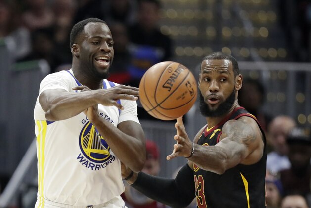 Golden State Warriors' Draymond Green, left, passes against Cleveland Cavaliers' LeBron James in the first half of an NBA basketball game, Monday, Jan. 15, 2018, in Cleveland. (AP Photo/Tony Dejak)
