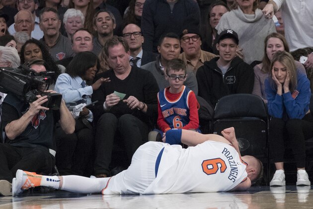 New York Knicks forward Kristaps Porzingis lies on the ground after being injured during the first half of the team's NBA basketball game against the Milwaukee Bucks, Tuesday, Feb. 6, 2018, at Madison Square Garden in New York. (AP Photo/Mary Altaffer)