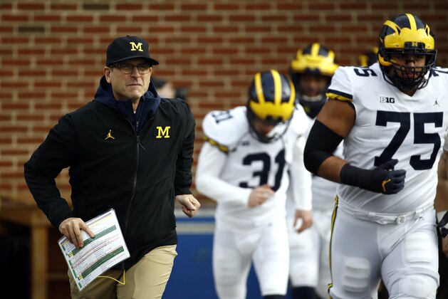 Michigan head coach Jim Harbaugh runs onto the field with his team before an NCAA college football game against Maryland in College Park, Md., Saturday, Nov. 11, 2017. (AP Photo/Patrick Semansky)