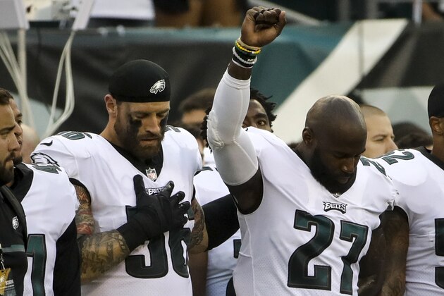 Philadelphia Eagles' Chris Long (56) stands beside Malcolm Jenkins (27) as he raises his fist during the national anthem before the team's NFL preseason football game against the Buffalo Bills, Thursday, Aug. 17, 2017, in Philadelphia. (AP Photo/Matt Rourke)