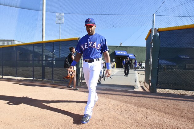 Seattle Seahawks quarterback Russell Wilson walks onto the practice field for  early infield practice prior to a Rangers spring training baseball game against the San Diego Padres, Saturday, March 28, 2015, in Surprise, Ariz.  (AP Photo/Lenny Ignelzi)
