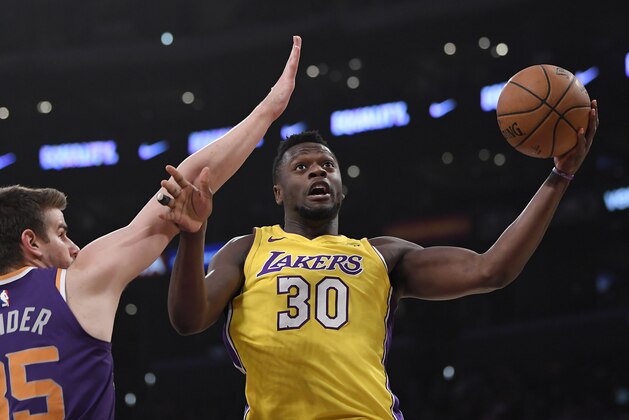 Los Angeles Lakers forward Julius Randle, right, shoots as Phoenix Suns forward Dragan Bender, of Croatia, defends during the first half of an NBA basketball game, Tuesday, Feb. 6, 2018, in Los Angeles. (AP Photo/Mark J. Terrill)