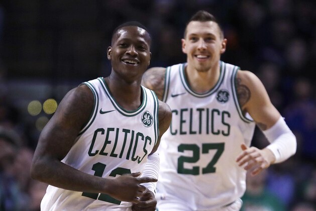 Boston Celtics guard Terry Rozier (12) smiles as he heads up court with forward Daniel Theis, after completing a triple-double with a pass to Theis for a slam dunk, during the second half of an NBA basketball game in Boston, Wednesday, Jan. 31, 2018. Rozier filled in nicely for the injured Kyrie Irving, logging his first career triple-double with 17 points, 11 rebounds and 10 assists in his first NBA start. The Celtics won 103-73. (AP Photo/Charles Krupa)