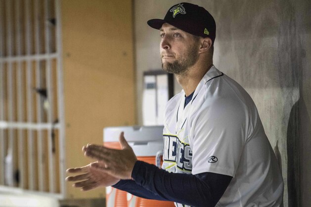 FILE - In this April 6, 2017, file photo, Columbia Fireflies outfielder Tim Tebow applauds from the dugout during a minor league baseball game against the Augusta GreenJackets in Columbia, S.C. The first half of Tebow’s first professional baseball season is complete. It did not end on a high note. The former Heisman winner struck out three times on Sunday, June 18, 2017,  as the Fireflies fell out of a playoff spot. Tebow did put together a five-game hitting streak that is his longest of the season for the New York Mets’ Single A franchise. (AP Photo/Sean Rayford, File)