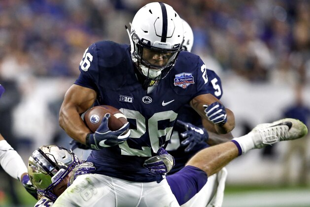 Penn State running back Saquon Barkley (26) runs as Washington linebacker Ben Burr-Kirven makes the tackle during the second half of the Fiesta Bowl NCAA college football game, Saturday, Dec. 30, 2017, in Glendale, Ariz. (AP Photo/Ross D. Franklin)