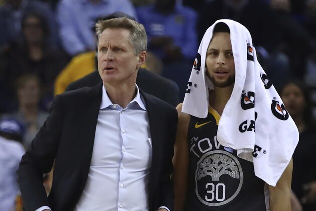 Golden State Warriors coach Steve Kerr, left, and Stephen Curry react to a technical foul called against Draymond Green during the first half of the team's NBA basketball game against the Dallas Mavericks on Thursday, Feb. 8, 2018, in Oakland, Calif. (AP Photo/Ben Margot)