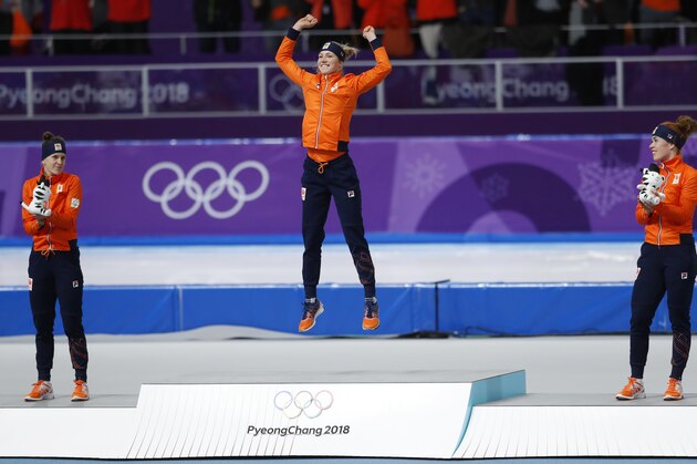 With a clean sweep for The Netherlands gold medallist Carlijn Achtereekte, center, jumps for joy as silver medallist Ireen Wust, left, and bronze medallist Antoinette de Jong, right, watch during the flower ceremony of the women's 3,000 meters race at the Gangneung Oval at the 2018 Winter Olympics in Gangneung, South Korea, Saturday, Feb. 10, 2018. (AP Photo/Petr David Josek)