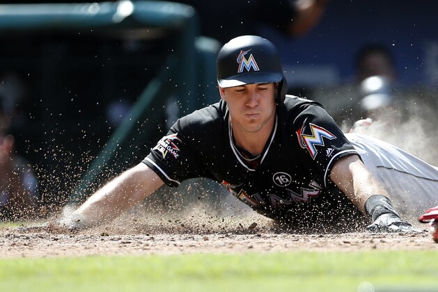 FILE - In this Aug. 24, 2017, file photo, Miami Marlins' J.T. Realmuto dives into home plate with a with a two-run inside the park home run against the Philadelphia Phillies during the sixth inning of a baseball game, in Philadelphia, Pa. A person familiar with the situation says Miami Marlins catcher J.T. Realmuto has requested a trade in the wake of the team’s latest payroll purge. The person confirmed the request to The Associated Press on condition of anonymity Monday, Dec. 18, 2017, because the Marlins didn’t comment. (AP Photo/Rich Schultz, File)