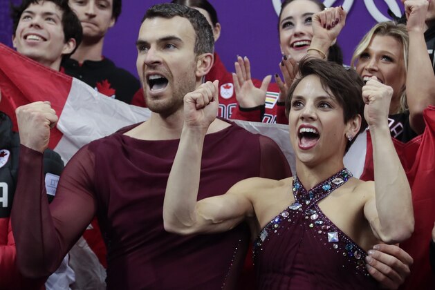 Meagan Duhamel and Eric Radford of Canada react with their teammates as they watch their scores posted following their performance in the team event pair skating in the Gangneung Ice Arena at the 2018 Winter Olympics in Gangneung, South Korea, Sunday, Feb. 11, 2018. (AP Photo/Julie Jacobson)