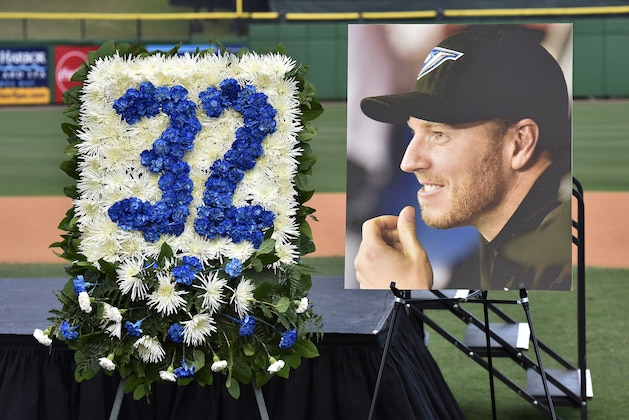 A photo of former Toronto Blue Jays pitcher Roy Halladay and a floral arrangement of his Toronto jersey number are on display during a memorial tribute for Halladay at the Philadelphia Phillies spring training baseball stadium, Tuesday, Nov. 14, 2017, in Clearwater, Fla. (AP Photo/Steve Nesius)