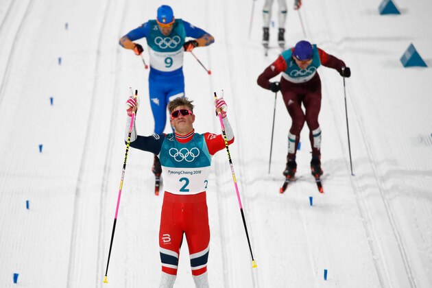 Norway's Johannes Hoesflot Klaebo celebrates crossing the finish line to win gold followed by Italy's Federico Pellegrino (L back) taking silver and Russia's Alexander Bolshunov winning bronze during the men's cross-country individual sprint classic final at the Alpensia cross country ski centre during the Pyeongchang 2018 Winter Olympic Games on February 13, 2018 in Pyeongchang.  / AFP PHOTO / Odd ANDERSEN        (Photo credit should read ODD ANDERSEN/AFP/Getty Images)