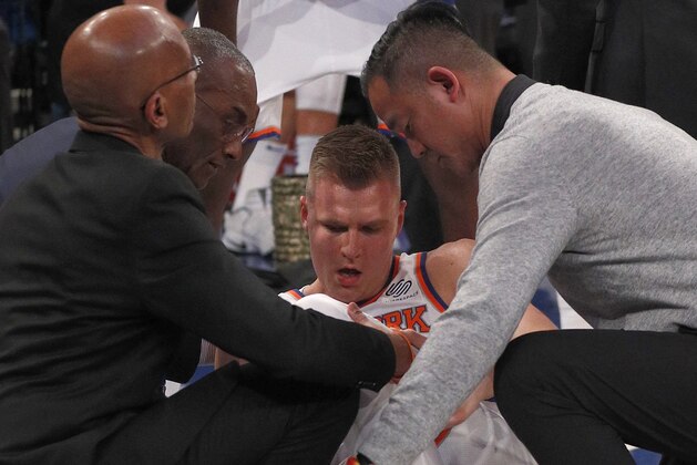 NEW YORK, NY - FEBRUARY 6: Kristaps Porzingis #6 of the New York Knicks is helped by members of the Knicks medical staff after  tearing his ACL in his left knee during the second quarter of an NBA basketball game against the Milwaukee Bucks on February 6, 2018 at Madison Square Garden Center in New York City. Bucks won 103-89. NOTE TO USER: User expressly acknowledges and agrees that, by downloading and/or using this Photograph, user is consenting to the terms and conditions of the Getty License agreement. Mandatory Copyright Notice (Photo by Paul Bereswill/Getty Images)