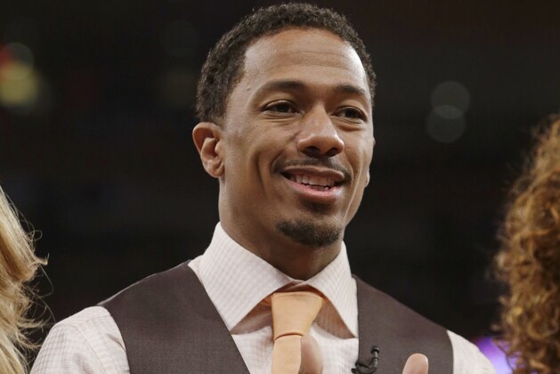 Nick Cannon poses for photographs during the first half of an NBA basketball game between the New York Knicks and the Brooklyn Nets Wednesday, April 2, 2014, in New York.  (AP Photo/Frank Franklin II)