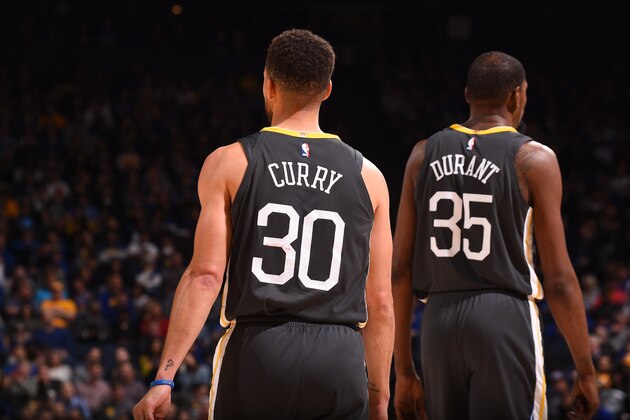 OAKLAND, CA - FEBRUARY 12:  Stephen Curry #30 and Kevin Durant #35 of the Golden State Warriors are seen during the game against the Phoenix Suns on February 12, 2018 at ORACLE Arena in Oakland, California. NOTE TO USER: User expressly acknowledges and agrees that, by downloading and or using this photograph, user is consenting to the terms and conditions of Getty Images License Agreement. Mandatory Copyright Notice: Copyright 2018 NBAE (Photo by Noah Graham/NBAE via Getty Images)