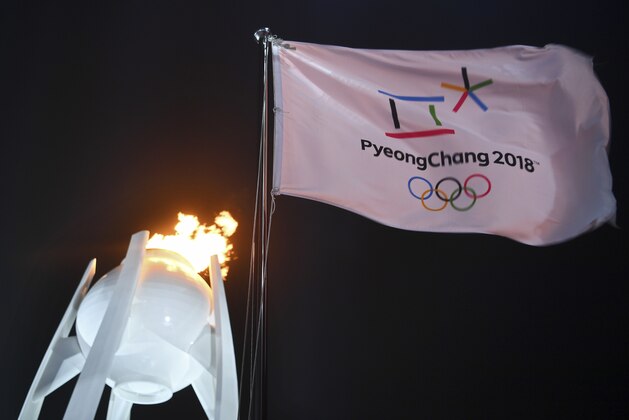 A flag flies in front of the Olympic flame during the opening ceremony of the 2018 Winter Olympics in Pyeongchang, South Korea, Friday, Feb. 9, 2018. (Franck Fife/Pool Photo via AP)
