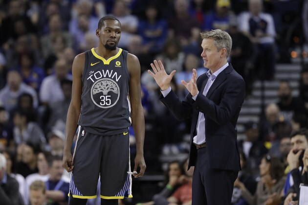Golden State Warriors head coach Steve Kerr, right, talks to Kevin Durant (35) during the second half of an NBA basketball game against the Oklahoma City Thunder Tuesday, Feb. 6, 2018, in Oakland, Calif. (AP Photo/Marcio Jose Sanchez)