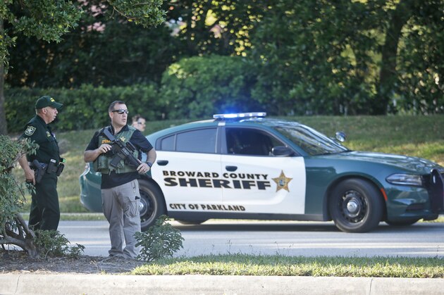 Law enforcement officers block off a street following a shooting at Marjory Stoneman Douglas High School, Wednesday, Feb. 14, 2018, in Parkland, Fla. (AP Photo/Wilfredo Lee)