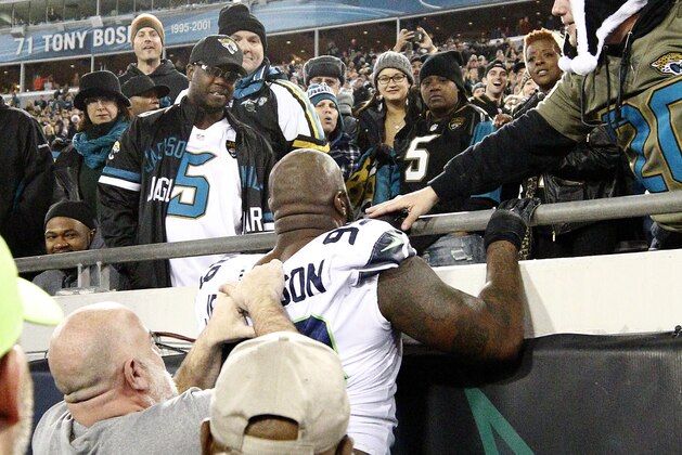 Seattle Seahawks defensive tackle Quinton Jefferson, center, tries to climb up in the stands after Jacksonville Jaguars fans threw objects at him in the closing moments of an NFL football game, Sunday, Dec. 10, 2017, in Jacksonville, Fla. Jacksonville won 30-24. (AP Photo/Stephen B. Morton)