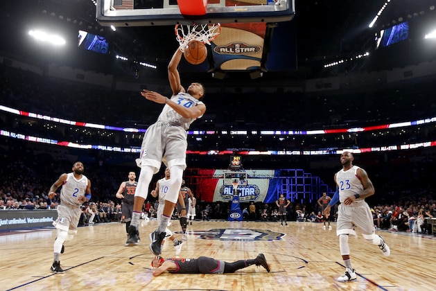 FILE- In this Feb. 20, 2017, file pool photo, Eastern Conference small forward Giannis Antetokounmpo, of the Milwaukee Bucks, dunks as Western Conference guard Stephen Curry, bottom, of the Golden State Warriors, lies on the court during the first half of the NBA All-Star basketball game in New Orleans. The NBA is scrapping the East against West format for its All-Star Game and will have captains pick teams this season. (AP Photo/Max Becherer, Pool, File)