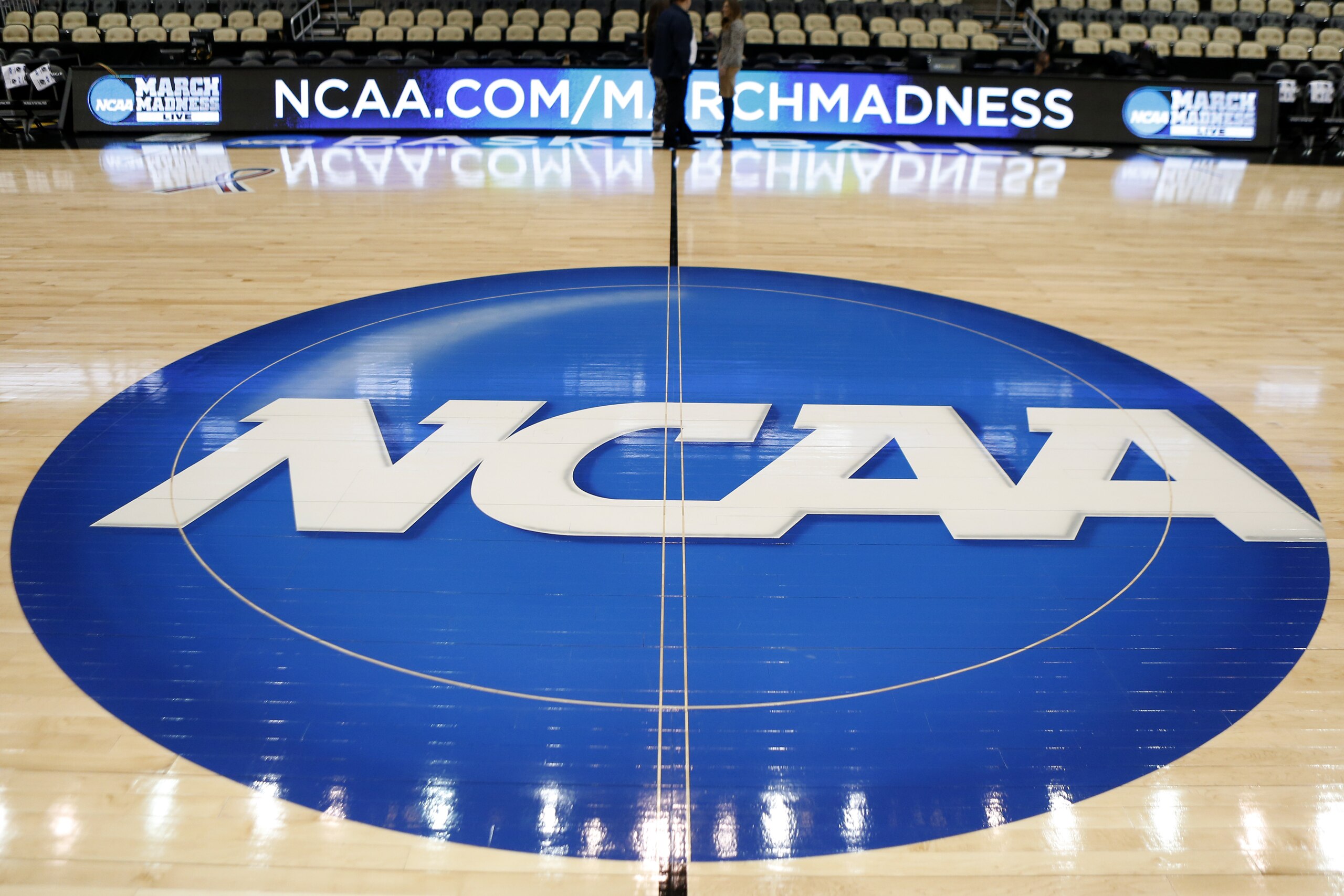 FILE - In this March 18, 2015, file photo, the NCAA logo is at center court as work continues at The Consol Energy Center in Pittsburgh, for the NCAA college basketball second and third round games.  The NCAA and 11 major athletic conferences announced Friday, Feb. 3, 2017,  they have agreed to pay $208.7 million to settle a federal class-action lawsuit filed by former college athletes who claimed the value of their scholarships was illegally capped. (AP Photo/Keith Srakocic, File)