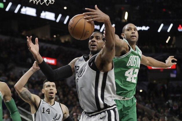 San Antonio Spurs forward LaMarcus Aldridge (12) and Boston Celtics forward Al Horford (42) reach for a rebound during the first half of an NBA basketball game Friday, Dec. 8, 2017, in San Antonio. (AP Photo/Eric Gay)
