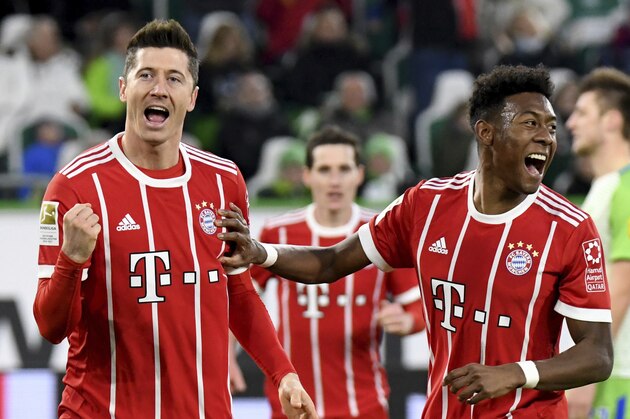 Munich's  Robert Lewandowski, left, and teammate  David Alaba celebrate  the 2-1 leading goal during the German Bundesliga soccer match between VfL Wolfsburg and Bayern Munich, in Wolfsburg, northern Germany, Saturday, Feb. 17, 2018. (Peter Steffen/dpa via AP)