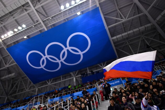 A spectator waves the Russia flag during the men's preliminary round ice hockey match between the Olympic Athletes from Russia and Slovenia during the Pyeongchang 2018 Winter Olympic Games at the Gangneung Hockey Centre in Gangneung on February 16, 2018.   / AFP PHOTO / Brendan Smialowski        (Photo credit should read BRENDAN SMIALOWSKI/AFP/Getty Images)