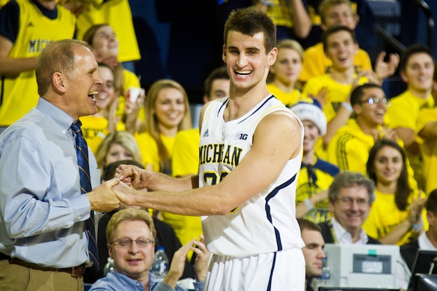 FILE - In this Dec. 22, 2014, file photo, Michigan head coach John Beilein, left, congratulates guard Austin Hatch (30) as he comes off the court in the second half of an NCAA college basketball game against Coppin State at Crisler Center in Ann Arbor, Mich. Michigan basketball coach John Beilein has announced that Austin Hatch will go on a medical scholarship and remain with the Wolverines as an undergraduate student assistant. Hatch survived two airplane crashes eight years apart, including a 2011 crash that severely injured him and killed his father and stepmother. Hatch's mother, brother and sister were killed in the first crash. He played in five games as a freshman last season. Beilein said the school received approval from the Big Ten on Monday, April 27, 2015, for a medical exemption waiver. (AP Photo/Tony Ding, File)