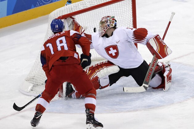 Dominik Kubalik (18), of the Czech Republic, shoots the puck past goalie Jonas Hiller (1), of Switzerland, for a goal during the third period of the preliminary round of the men's hockey game at the 2018 Winter Olympics in Gangneung, South Korea, Sunday, Feb. 18, 2018. (AP Photo/Matt Slocum)