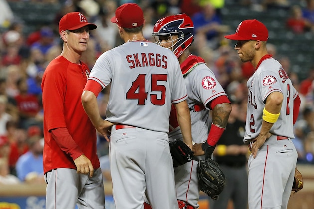 Los Angeles Angels pitching coach Charles Nagy visits with starting pitcher Tyler Skaggs (45), Martin Maldonado, second from right, and Andrelton Simmons, right, on the mound in the second inning of a baseball game against the Texas Rangers on Friday, Sept. 1, 2017, in Arlington, Texas. (AP Photo/Tony Gutierrez)