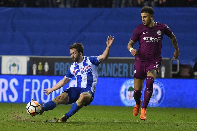 Wigan Athletic's English-born Northern Irish striker Will Grigg (L) scores his team's first goal during the English FA Cup fifth round football match between Wigan Athletic and Manchester City at the DW Stadium in Wigan, northwest England, on February 19, 2018. / AFP PHOTO / Oli SCARFF / RESTRICTED TO EDITORIAL USE. No use with unauthorized audio, video, data, fixture lists, club/league logos or 'live' services. Online in-match use limited to 75 images, no video emulation. No use in betting, games or single club/league/player publications.  /         (Photo credit should read OLI SCARFF/AFP/Getty Images)