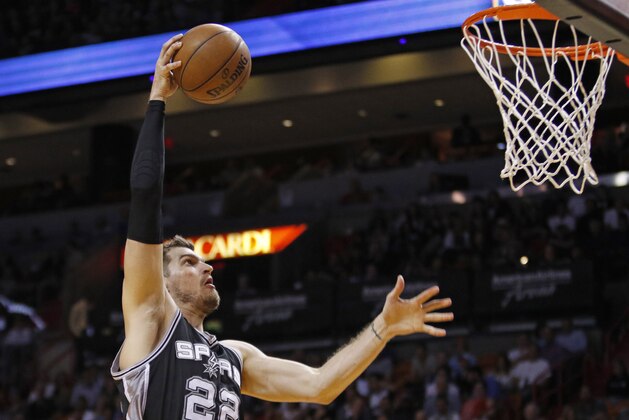 San Antonio Spurs center Tiago Splitter (22) goes high to dunk the ball against the Miami Heat in the first half of an NBA basketball game, Tuesday, March 31, 2015, in Miami. (AP Photo/Joe Skipper)