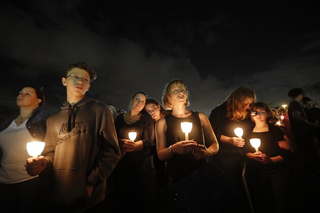 People participate in a candlelight vigil in memory of the 17 students and faculty who were killed in the Wednesday mass shooting at Marjory Stoneman Douglas High School in Parkland, Fla., Monday, Feb. 19, 2018. Nikolas Cruz, a former student, was charged with 17 counts of premeditated murder on Thursday. (AP Photo/Gerald Herbert)