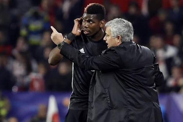 Manchester United manager Jose Mourinho, right, talks to Manchester United's Paul Pogba during the Champions League round of sixteen first leg soccer match between Sevilla FC and Manchester United at the Ramon Sanchez Pizjuan stadium in Seville, Spain, Wednesday, Feb. 21, 2018. (AP Photo/Miguel Morenatti)